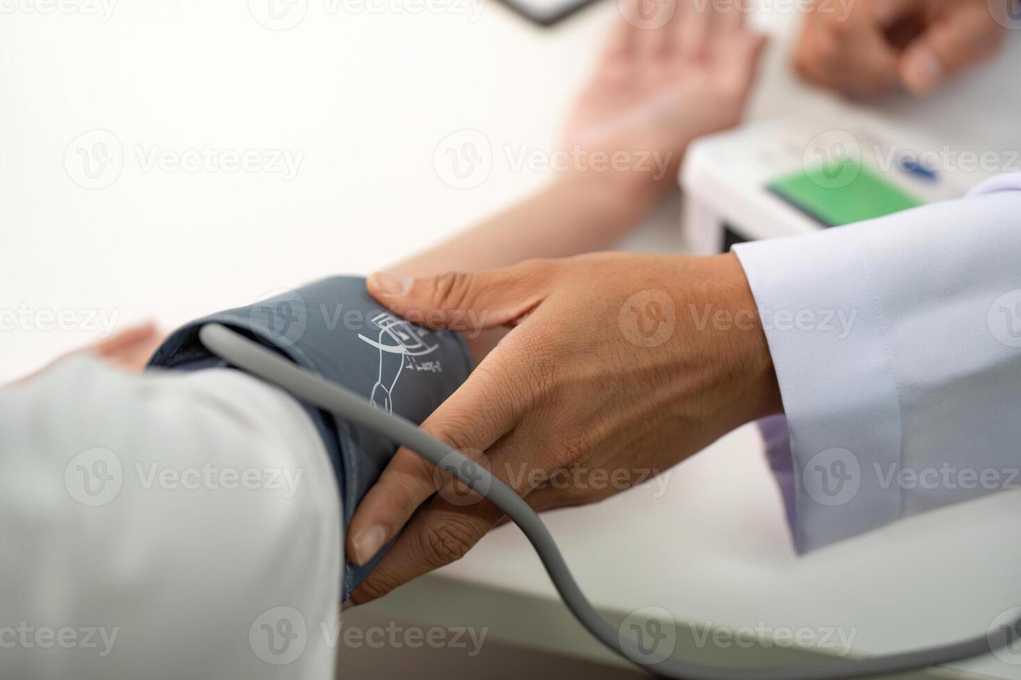 Blood Pressure Monitoring. Doctor measuring patient's blood pressure with a cuff. photo