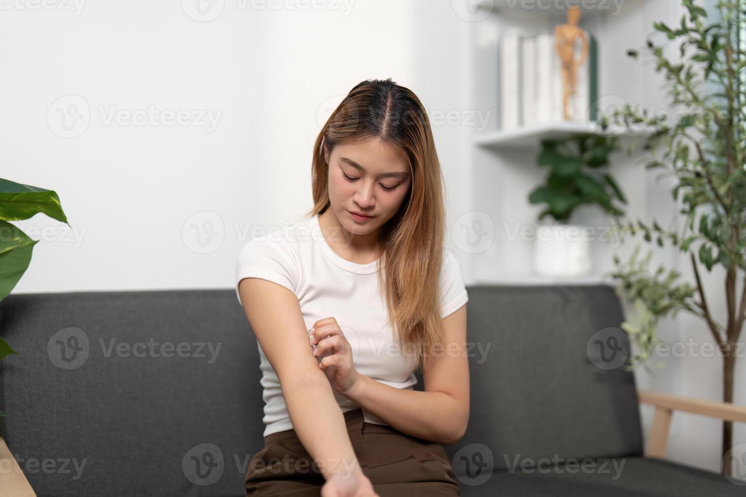 Health Awareness. Young woman examining her arm for discomfort. photo