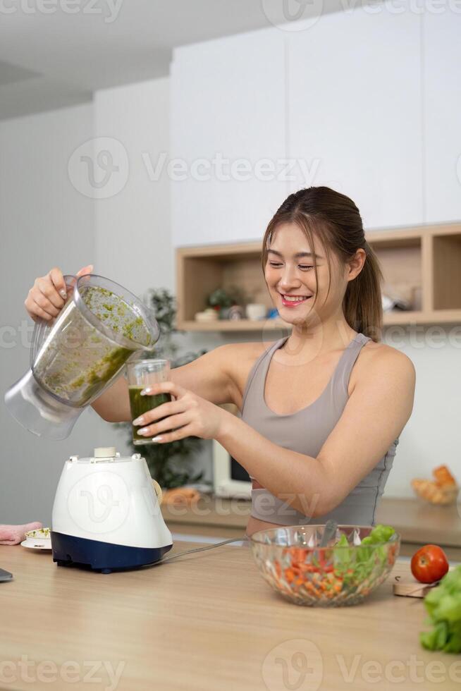 Woman blending smoothie in modern kitchen photo