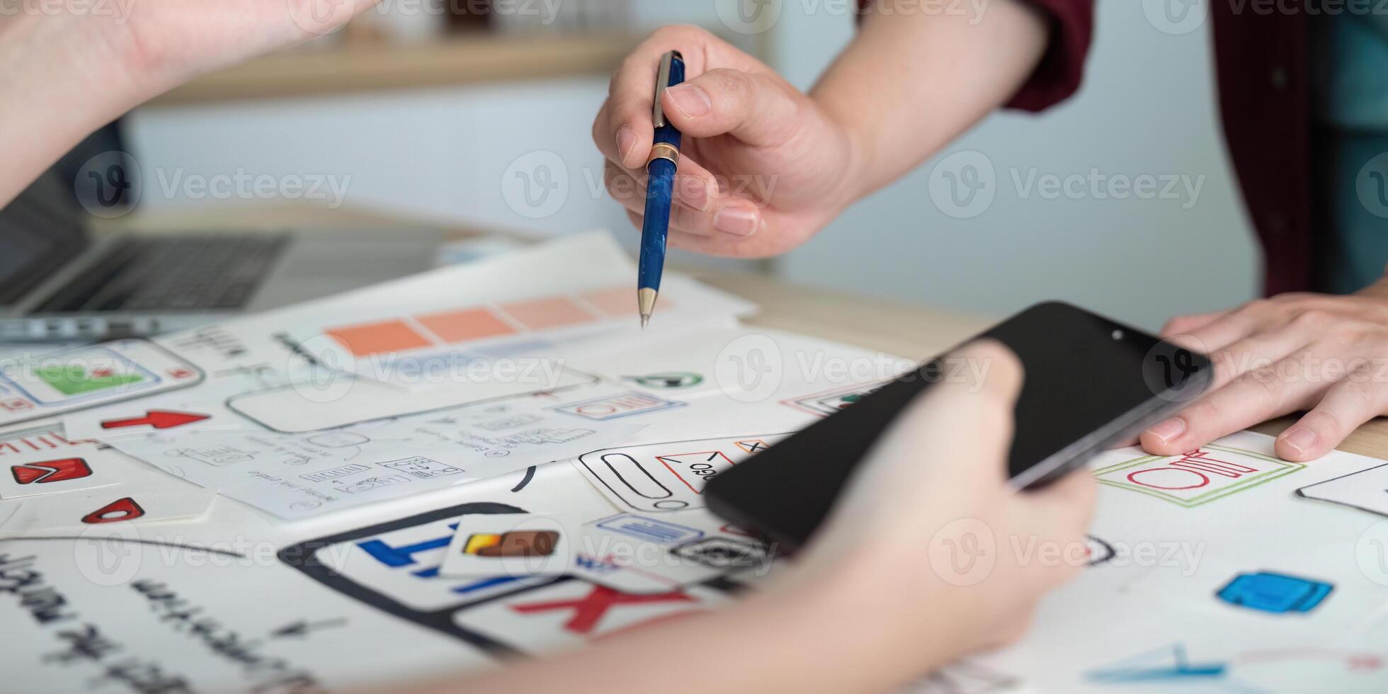 UX UI design collaboration. Team brainstorming with sketches and smartphone. photo