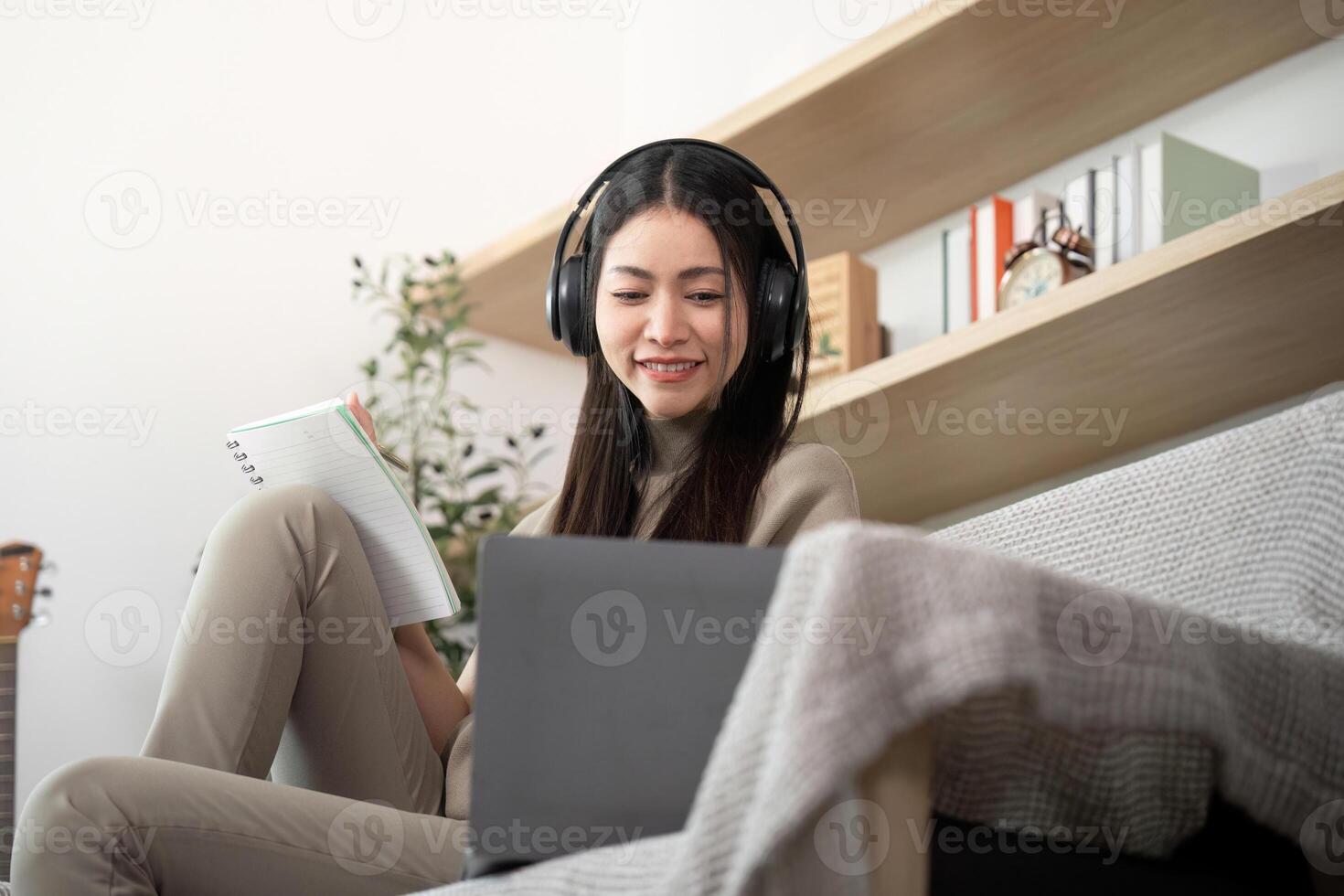 Woman with headphones studying on a laptop photo