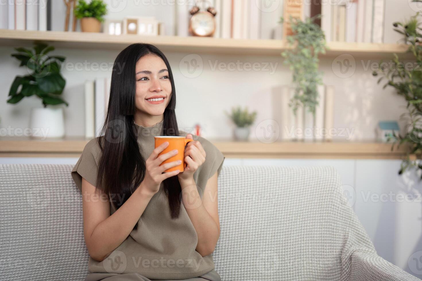Woman with orange cup on a sofa photo