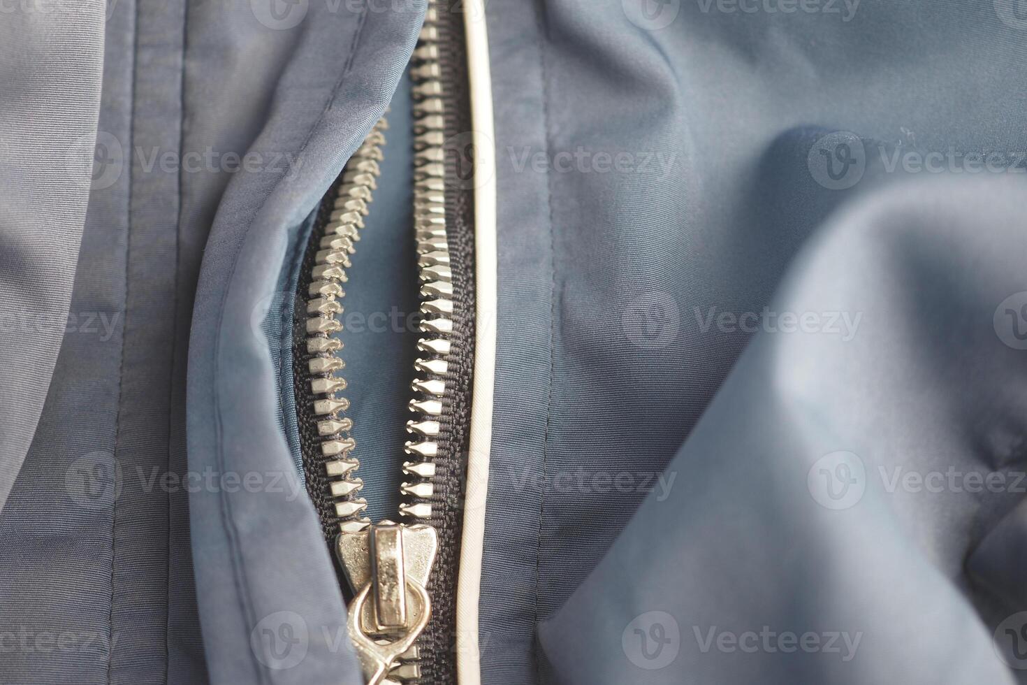 Close-up of a zipper on a blue fabric jacket photo