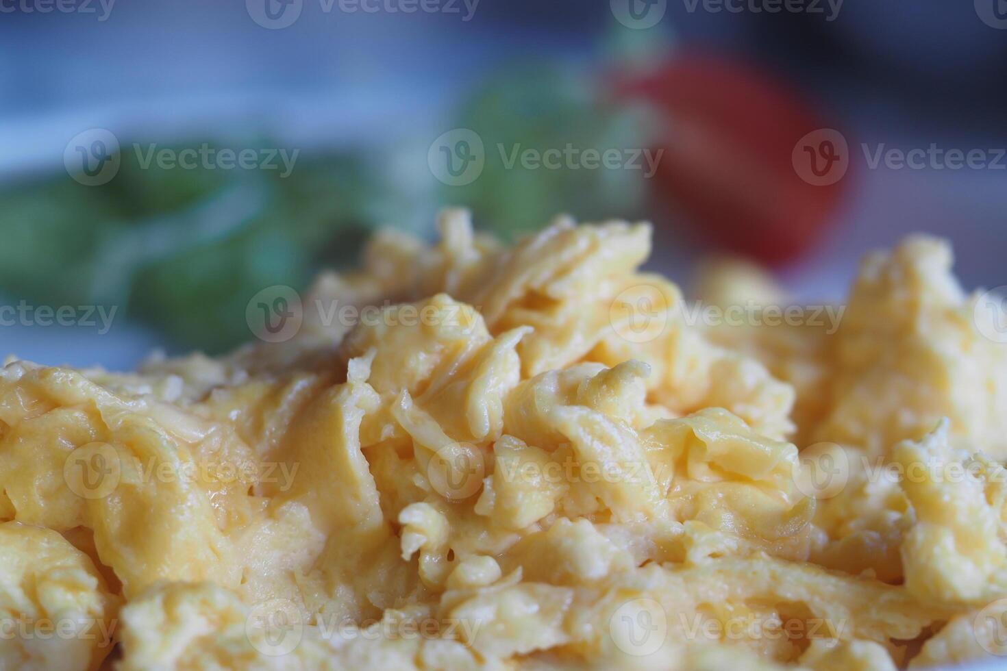 Delicious scrambled eggs with fresh salad on a plate photo