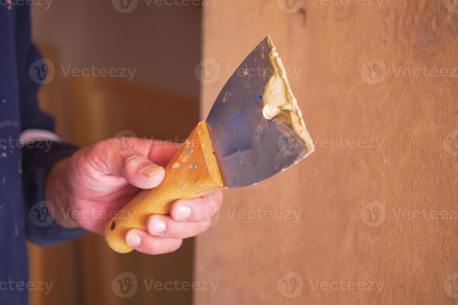 Demonstrating a taping knife for drywall application photo