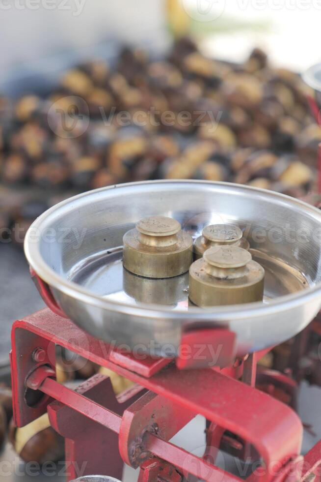 Weighing roasted chestnuts on a traditional scale photo
