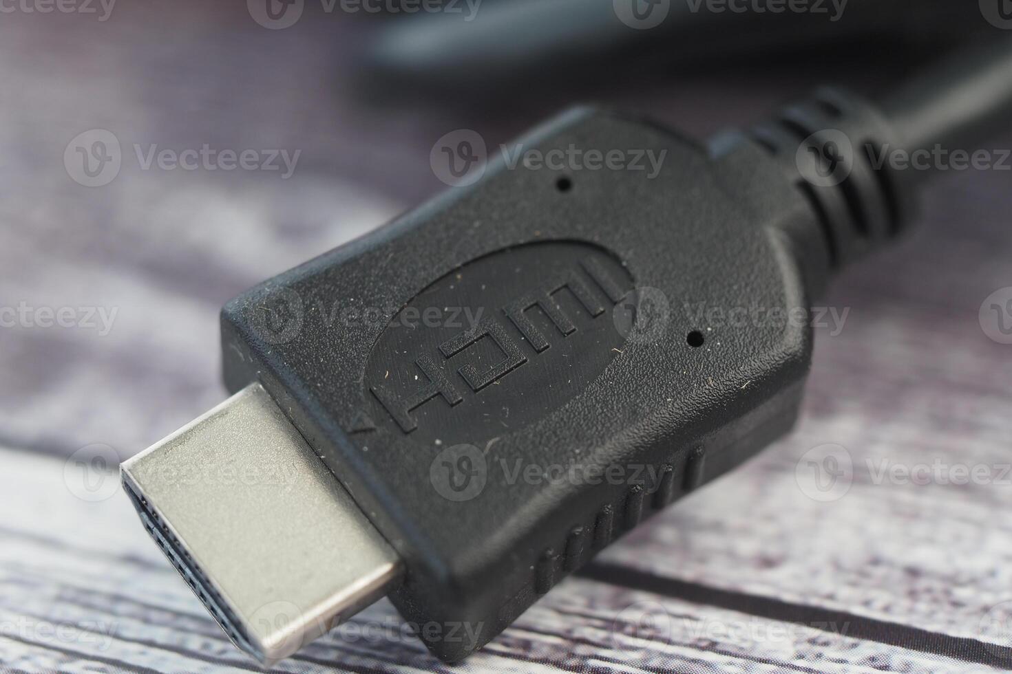 Close-up of a black HDMI cable connector on a wooden surface photo