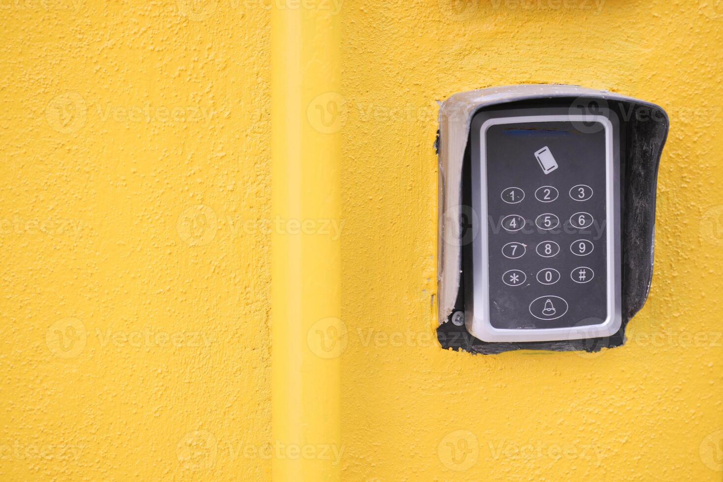 Keypad entry system on a bright yellow wall photo
