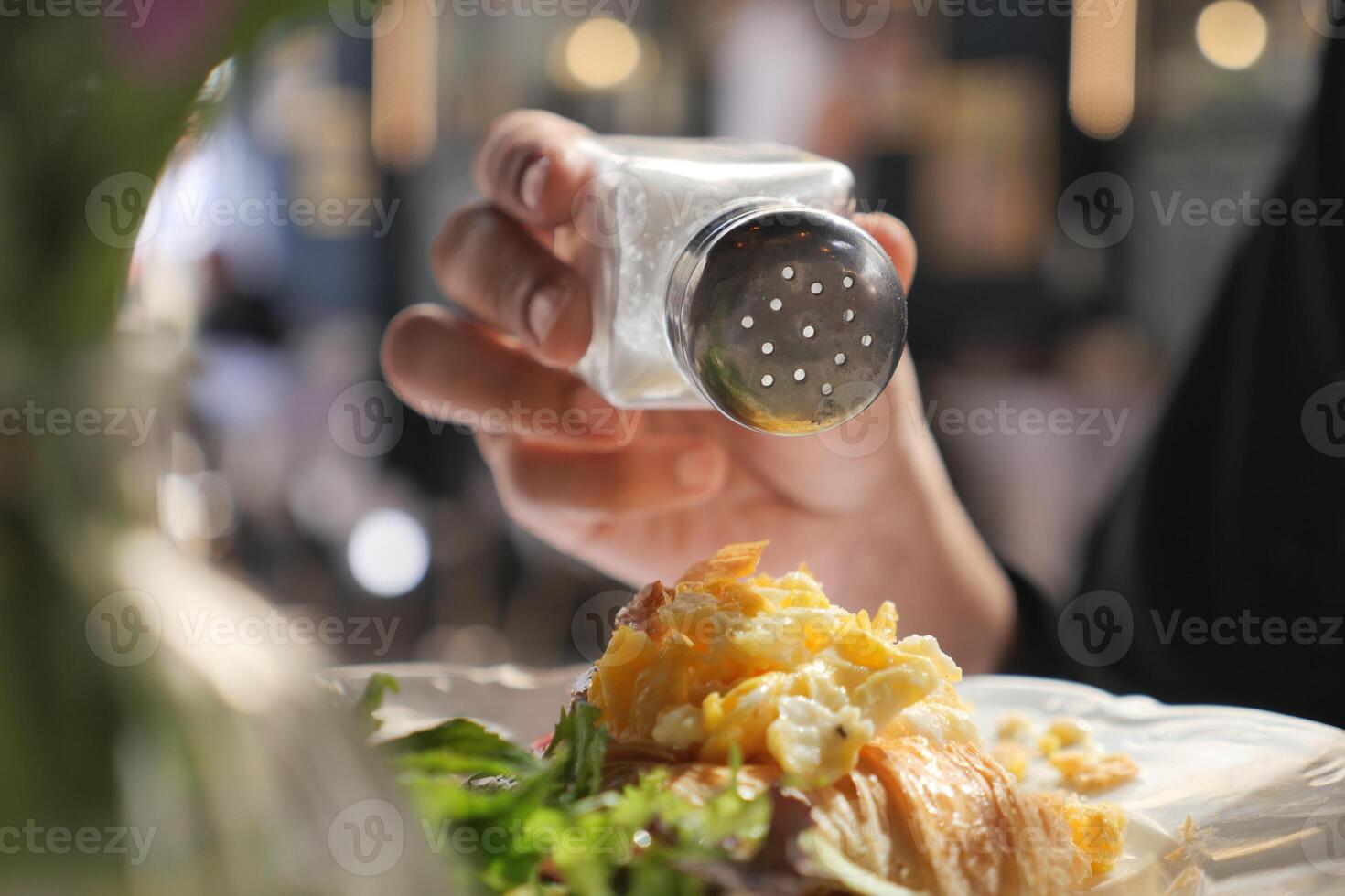Sprinkling seasoning on a delicious breakfast dish photo