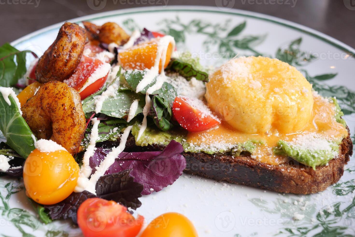 Colorful brunch plate with salad and toast topped with egg photo