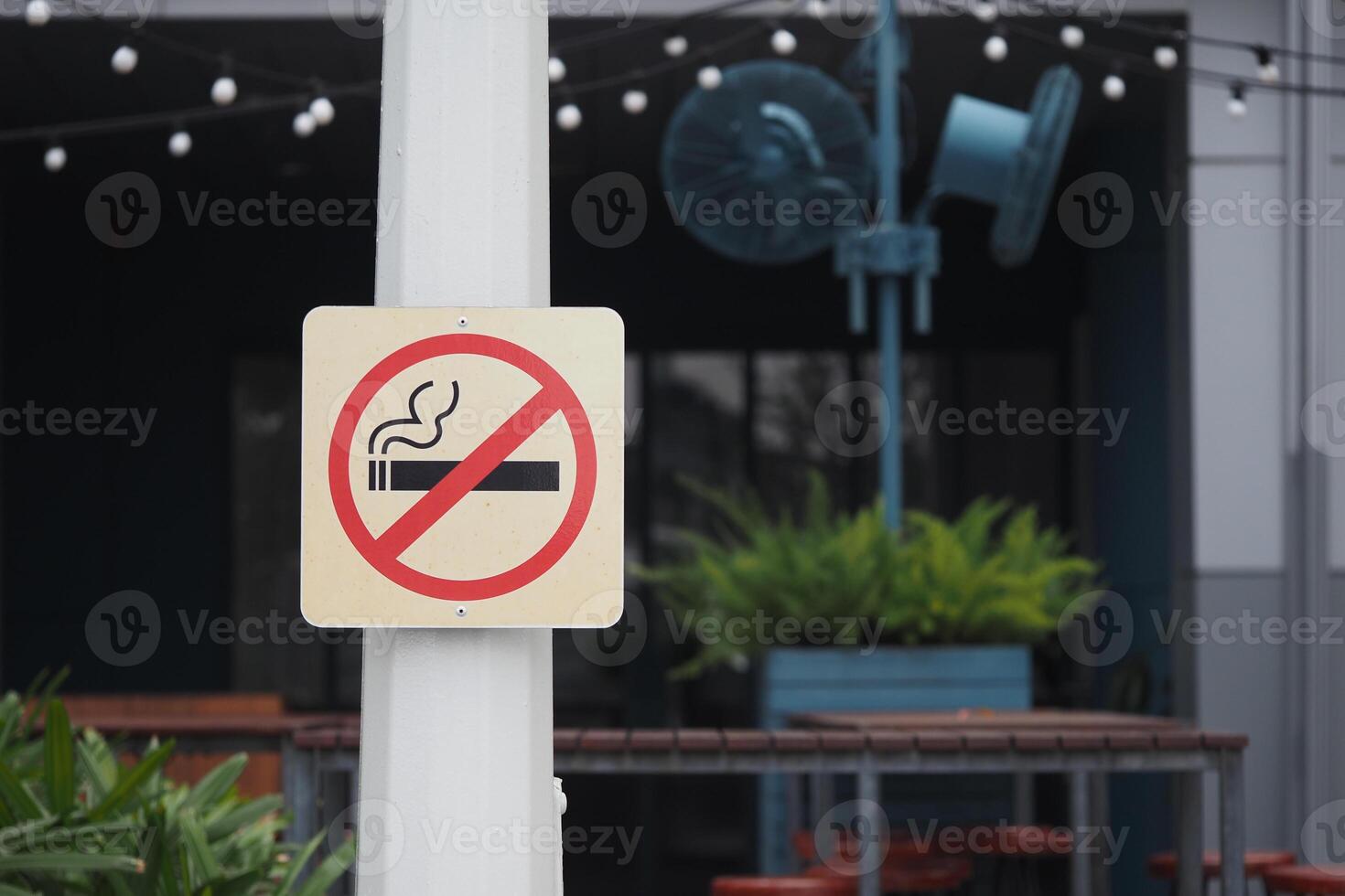 No smoking sign in outdoor cafe area during daytime photo