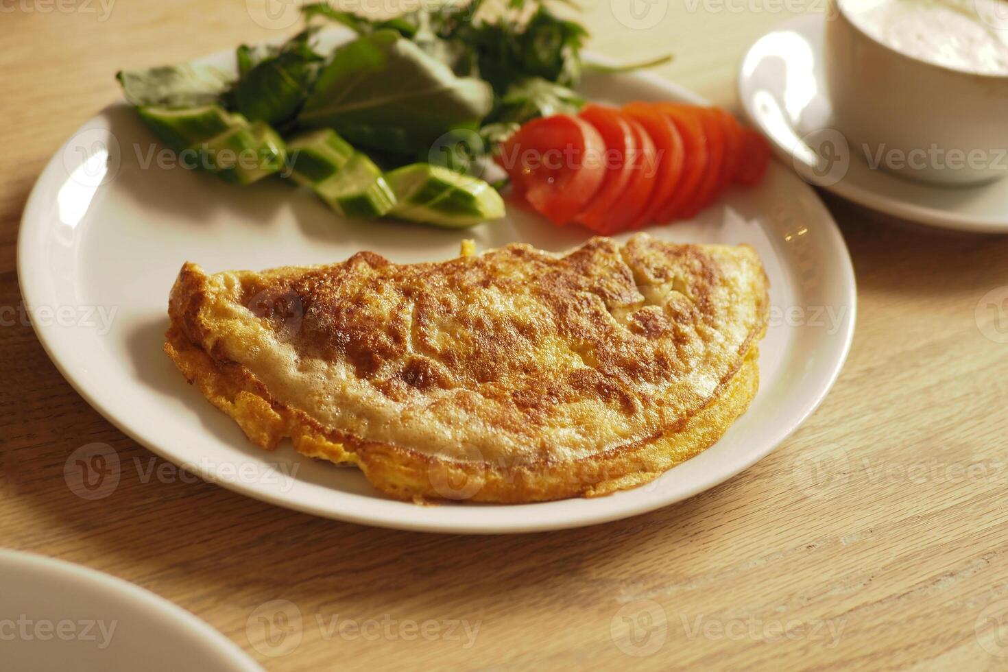 Delicious omelette with fresh salad and tomatoes at cafe photo