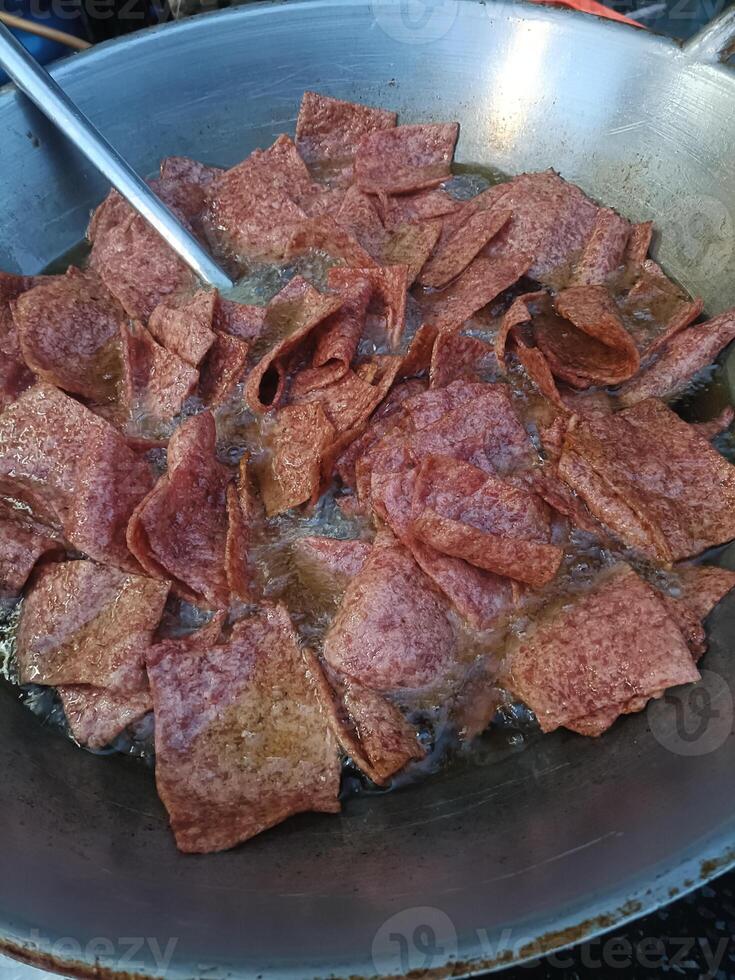 Crispy fried meat slices cooking in large pan, sizzling with oil, creating savory aroma and golden brown color, perfect for flavorful meal or snack photo