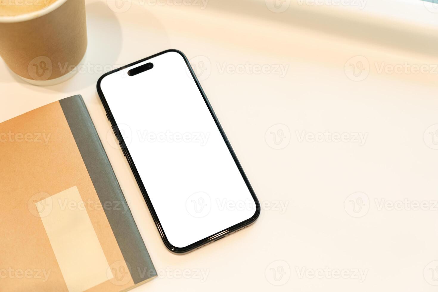 Office Desk with Blank Smartphone, Notebook, and Coffee. Copy space. The composition suggests a workspace ready for digital content or an app interface to be showcased. photo