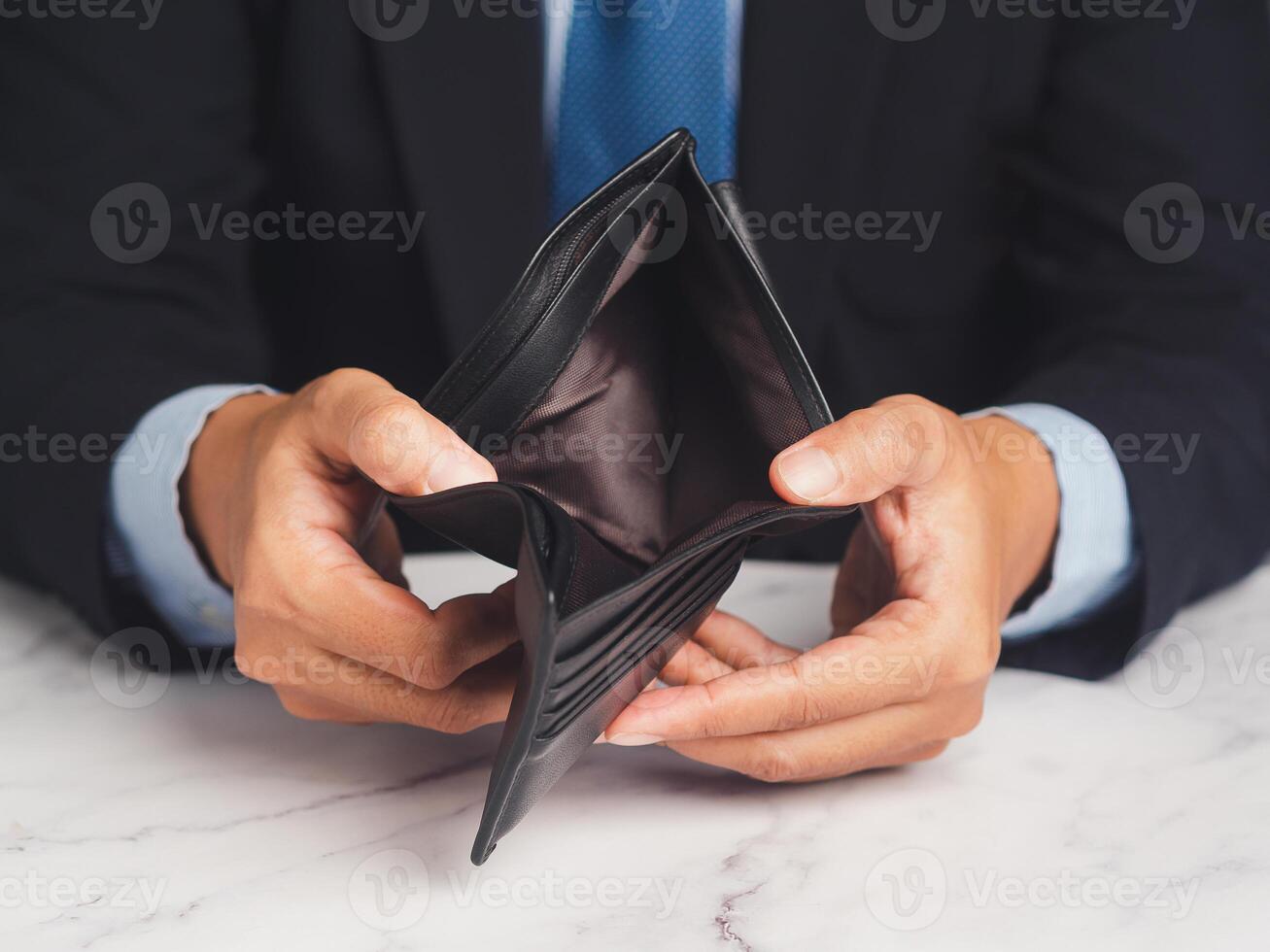 Close-up of hands opening an empty wallet while sitting at the table photo