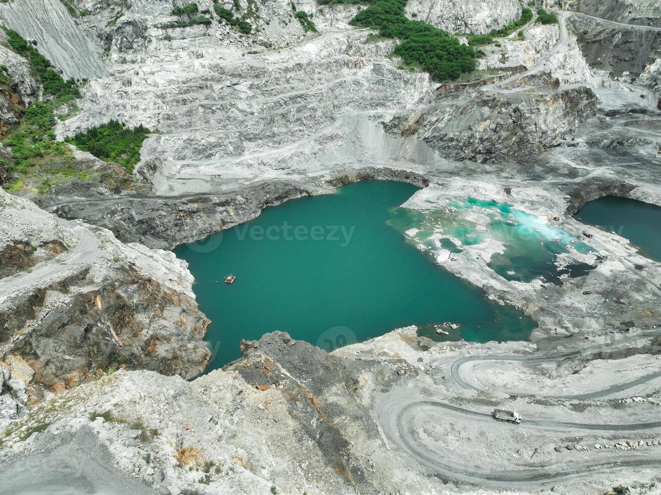 Open pit mine industry. Limestone quarry with truck in operation. Mining industry and construction material supply. Landscape of resource extraction in a industrial site. Gravel and cement production. photo