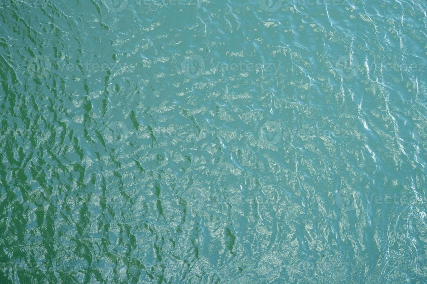 Top view of water surface texture with soft natural ripples. Background for eco-friendly design, peaceful concepts, and water sustainability. Aerial view blue green lake surface water background. photo