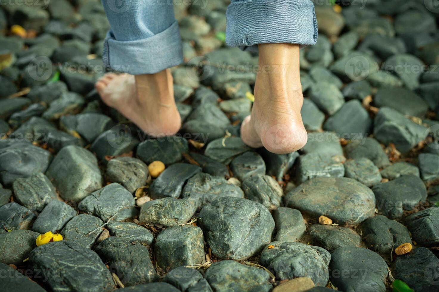 Barefoot woman walking on gravel ground in a peaceful forest retreat during early morning light. Self-care, emotional healing, and connection with nature for mental balance. Mindfulness. photo
