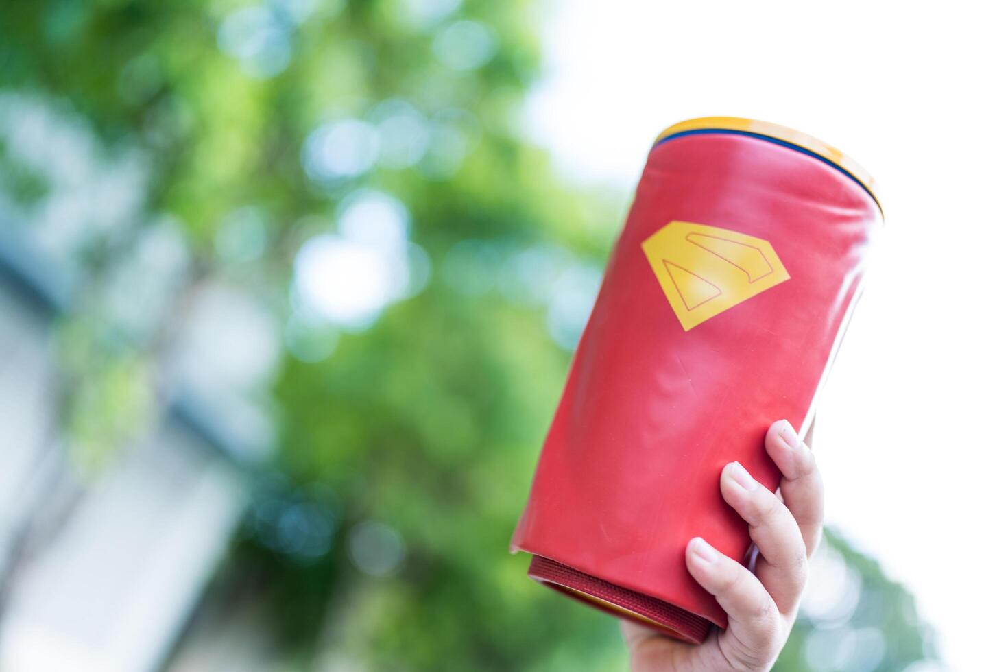 Bangkok, Thailand - July 8, 2025 Hand boy showing a cup of ice drink with a Superman pattern from Major Cineplex. photo