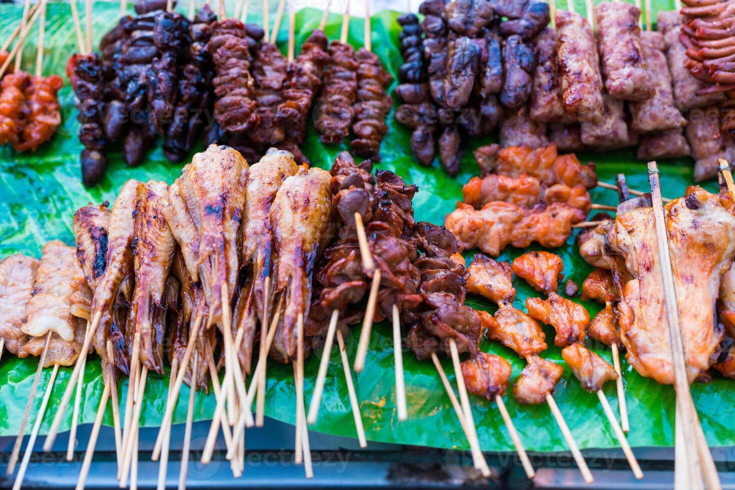 Traditional Thai street food with many grilled food in a wooden stick at local market. photo