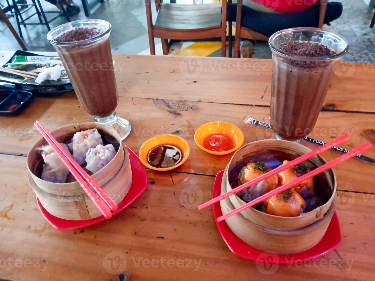 Dim Sum and Chocolate Drinks A Culinary Delight on Wooden Table photo