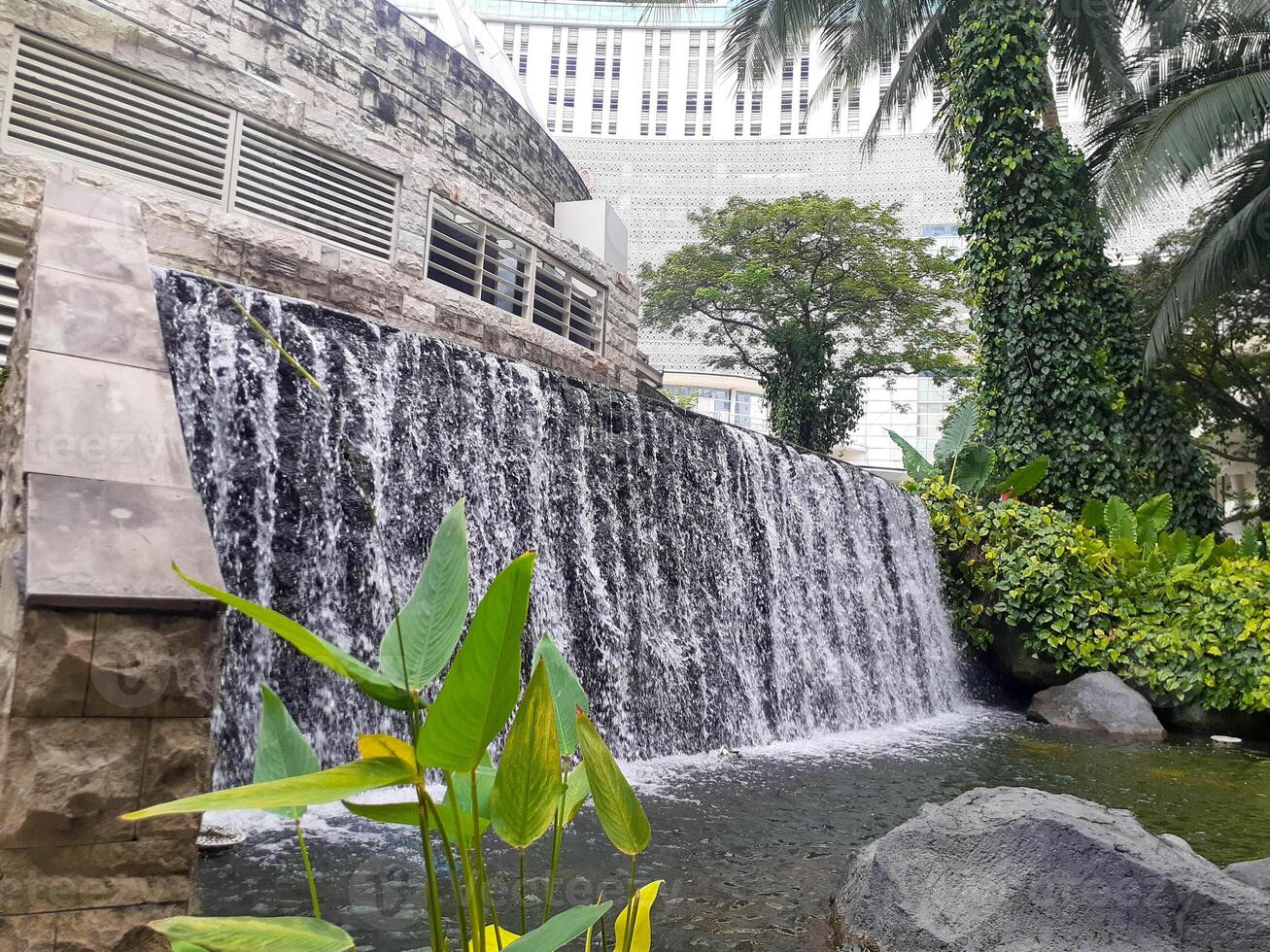 Urban Oasis Serene Waterfall Cascading Against Modern Architecture photo
