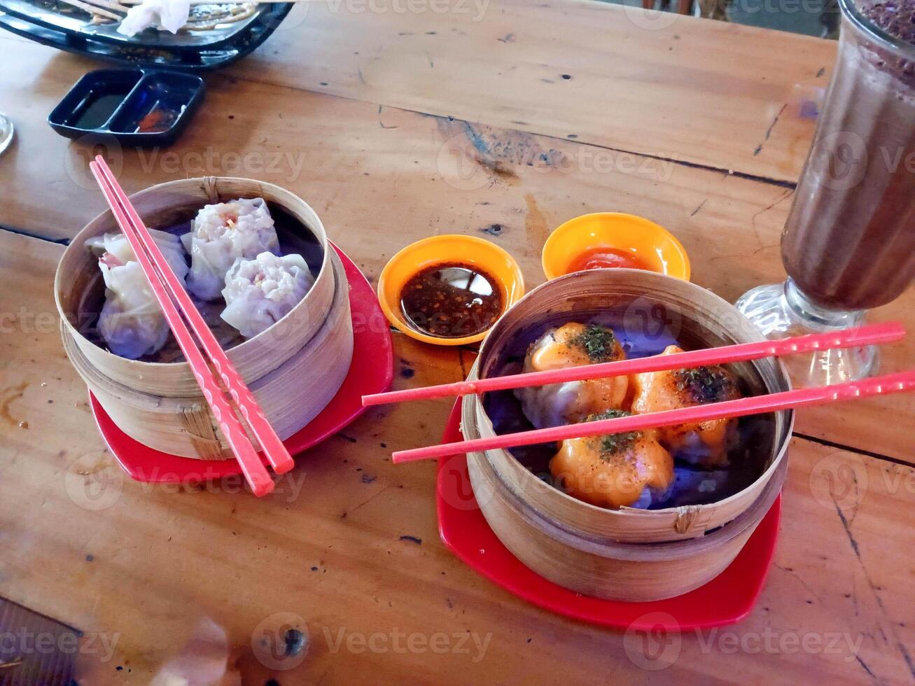 Dim Sum Delight Two Steaming Baskets with Chopsticks on Rustic Wooden Table photo