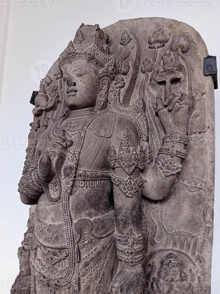 Ancient Stone Relief of a Deity with Intricate Carvings and Floral Motifs photo
