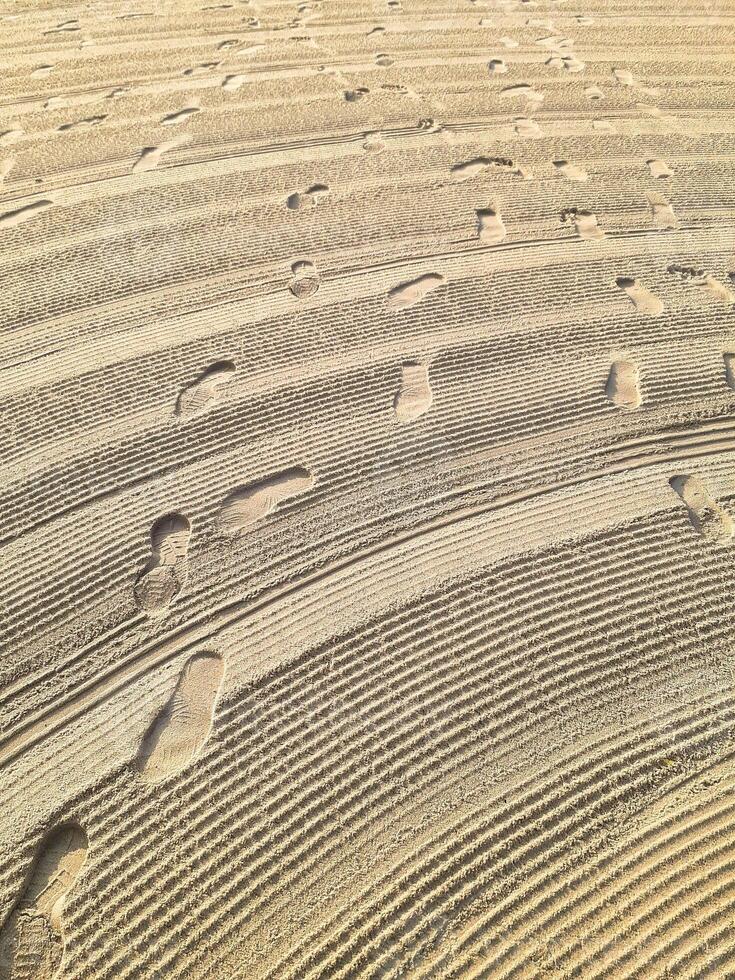 Serene Beach Sand Diagonal Lines Intersect Footprints, Golden Hour Light photo