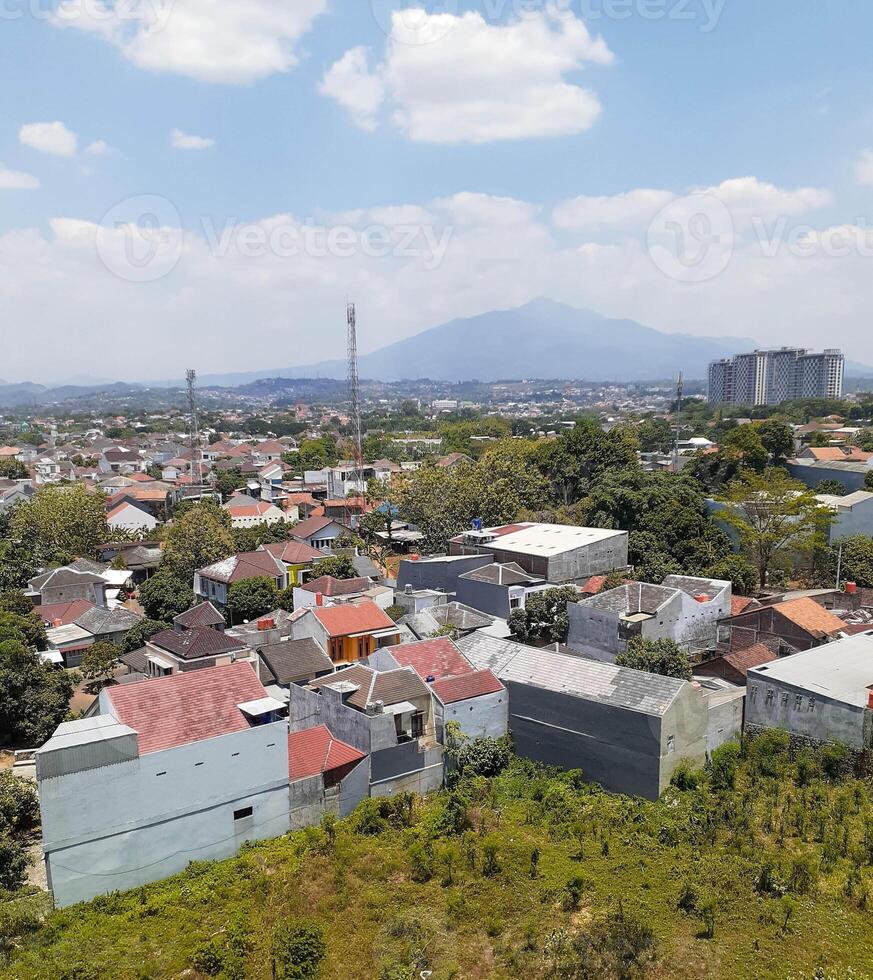 Urban Sprawl in Bandung, Indonesia Rooftops, Mountains, and Towering Buildings photo