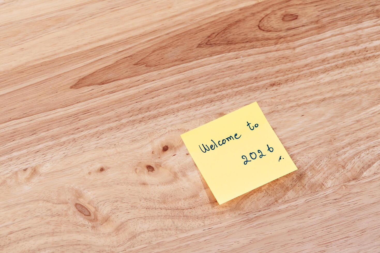 New beginnings a handwritten note welcoming 2026 a wooden desk inspiring thoughts calm environment photo