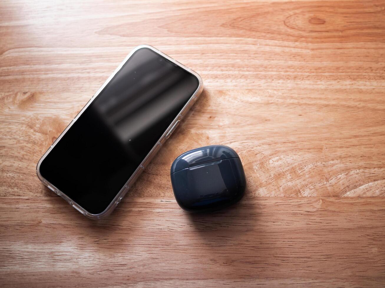 Mobile device and wireless earbuds home setting product minimalist style close-up view technology appeal photo