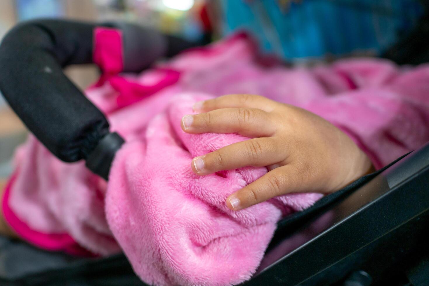 Baby hand holding soft blanket in stroller cozy environment close-up shot tender moment photo