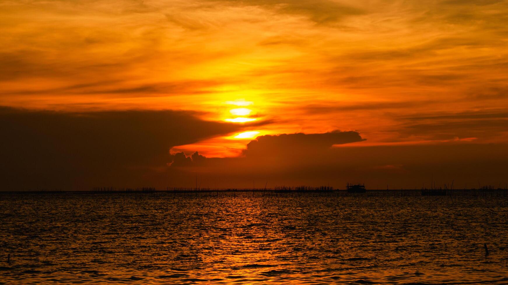 Sunset over calm waters coastal landscape nature imagery serene environment wide-angle view photo