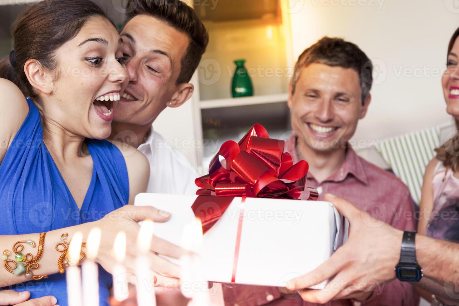 beautiful girl receiving birthday gift from her friends photo