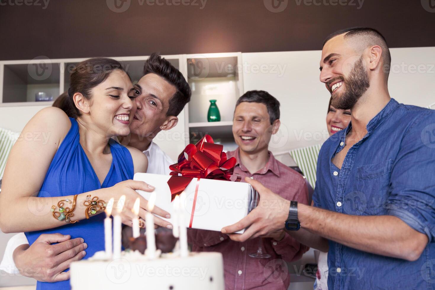 group of friends delivering a birthday present to a happy young woman photo