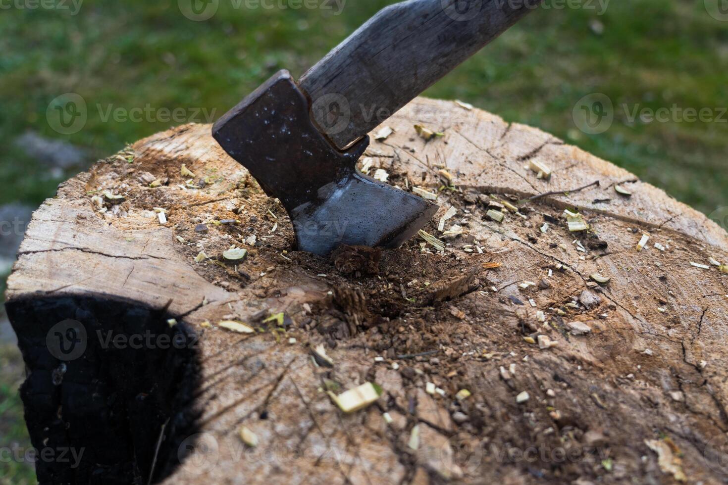 The axe is hammered into an oak block. Axe is stuck in the deck photo
