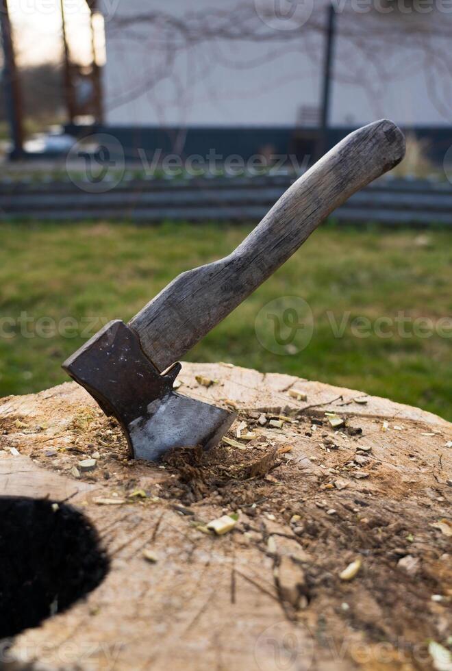 Axe is hammered into an oak block. The axe is stuck in the deck photo