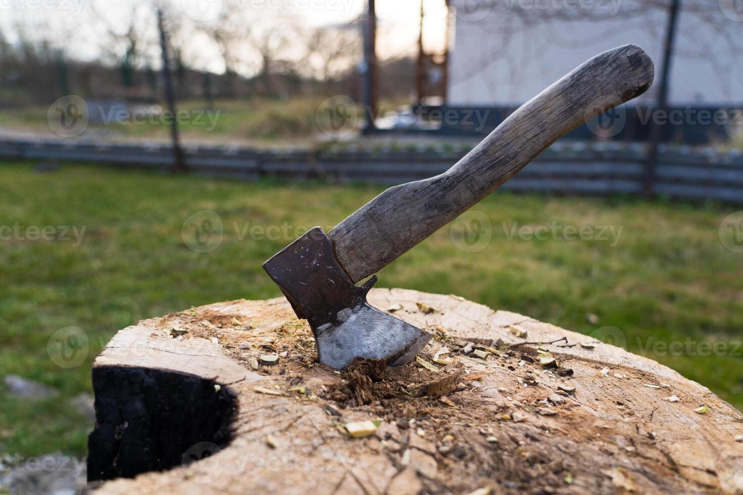 The axe is hammered into an oak block. The axe is stuck in the deck photo