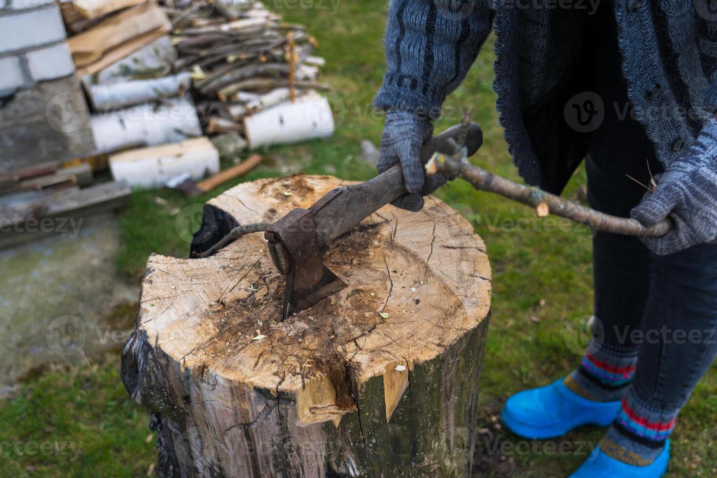 Cutting branches on the deck. girl cuts a branch with an axe photo