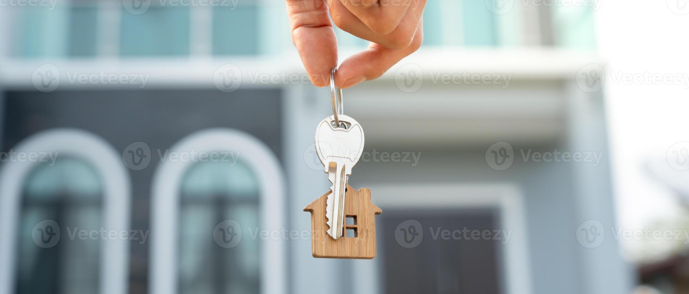 Hand holding keys with house charm photo