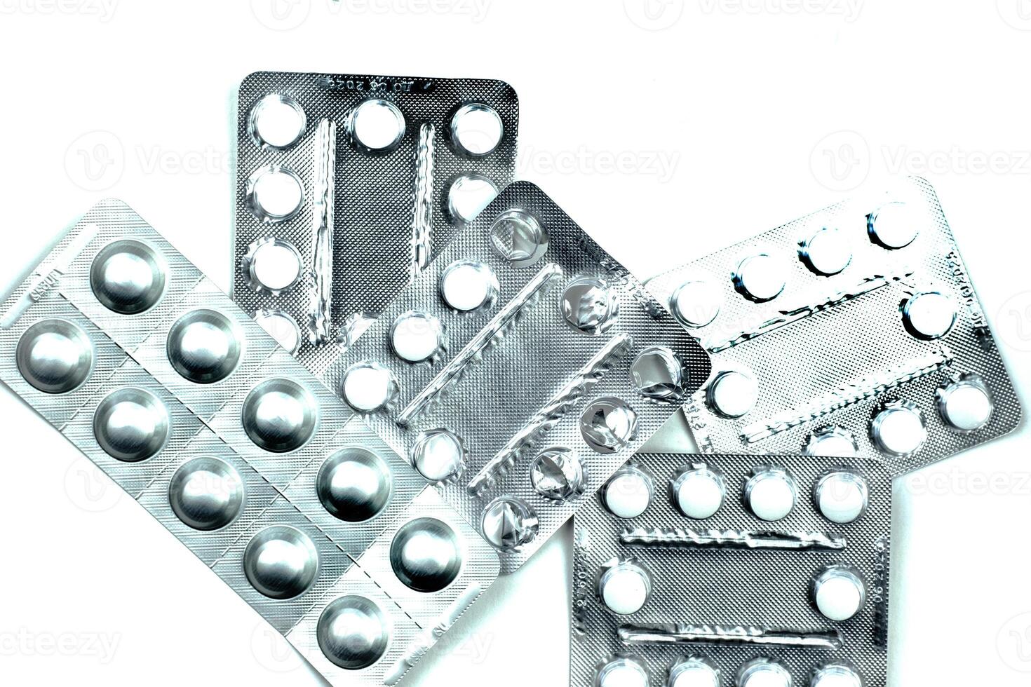 Pack of pills to improve health. Tablets and capsules in an aluminum container on a white table. photo