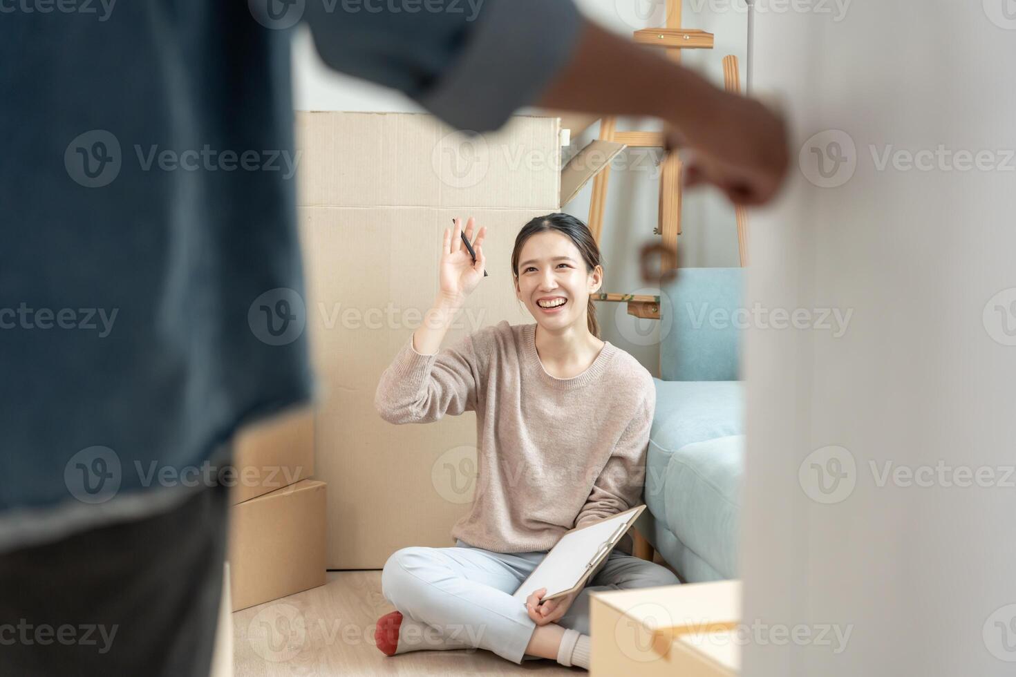 Moving house, relocation. Open the door found wife smile and play on new house, inside the room was a cardboard box contain personal belongings and furniture. move in the new apartment or home photo