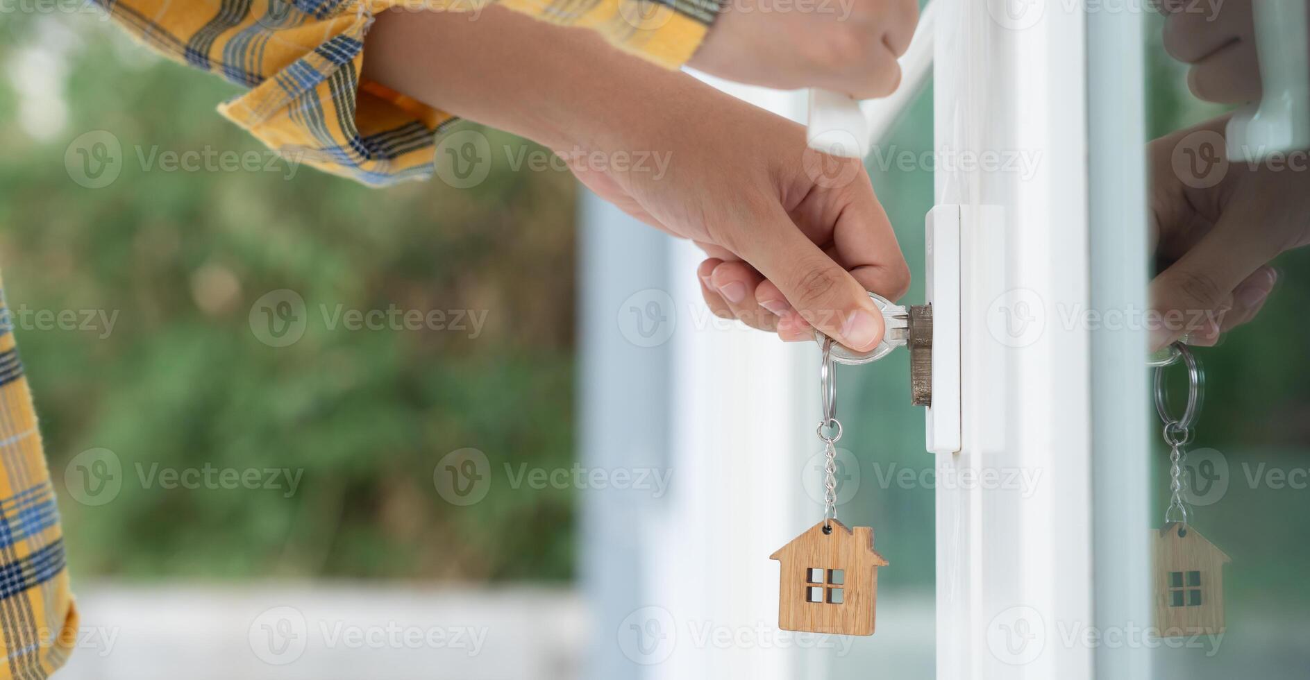 Landlord key for unlocking house is plugged into the door. Second hand house for rent and sale. Owner use hand unlock door mortgage for new home, buy, sell, renovate, investment. owner. photo