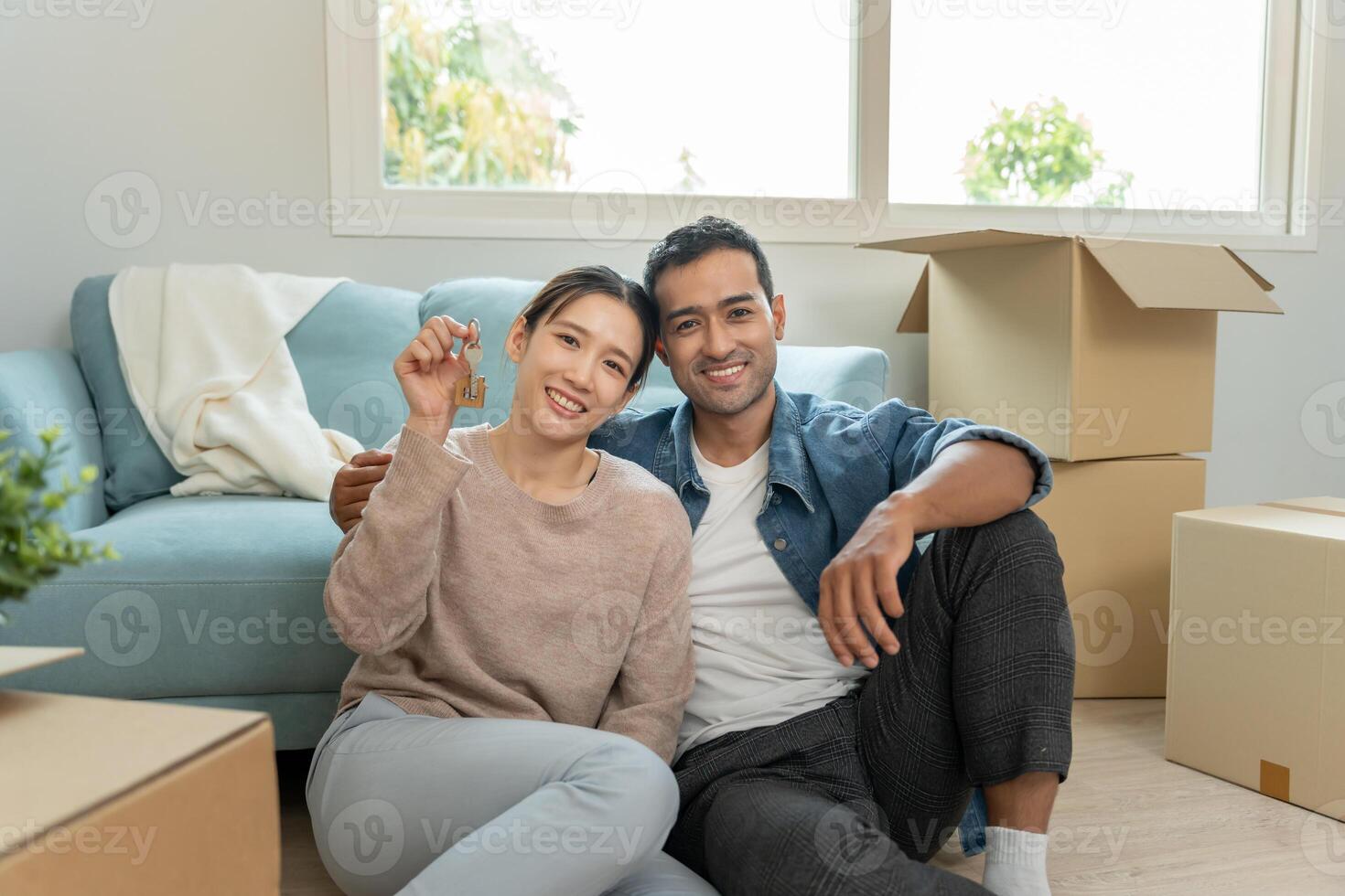 Moving house, relocation. Couple hold key for new house, inside the room was a cardboard box contain personal belongings. move in the new apartment or condominium, move furniture photo