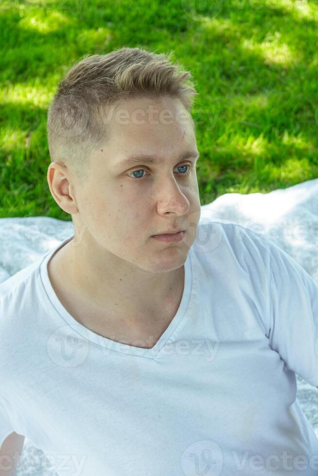 A young man, in a thoughtful pose, finds tranquility in natures calming beauty photo
