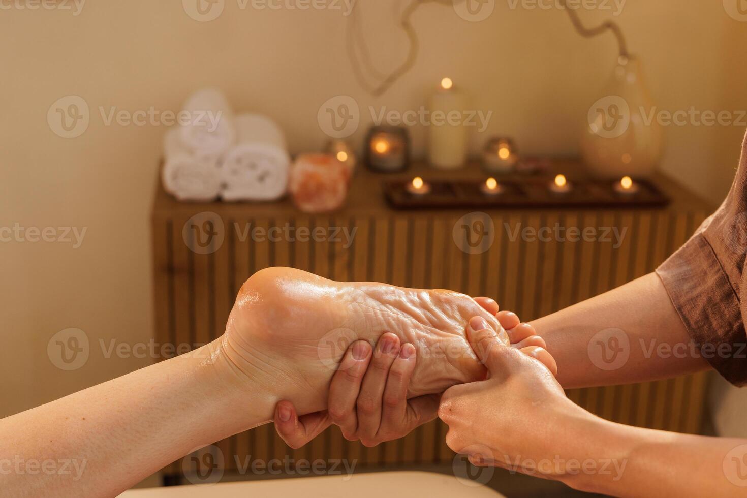 Close-up of a professional foot massage in a tranquil spa setting with oil, focusing on pressure points to relieve tension, enhance circulation, and promote full-body relaxation. photo