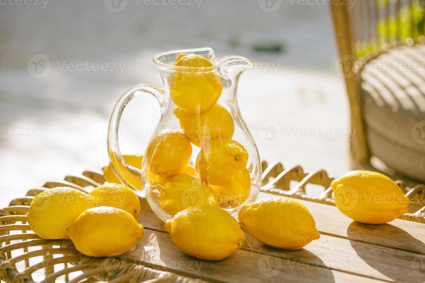 Fresh lemons in a glass pitcher photo