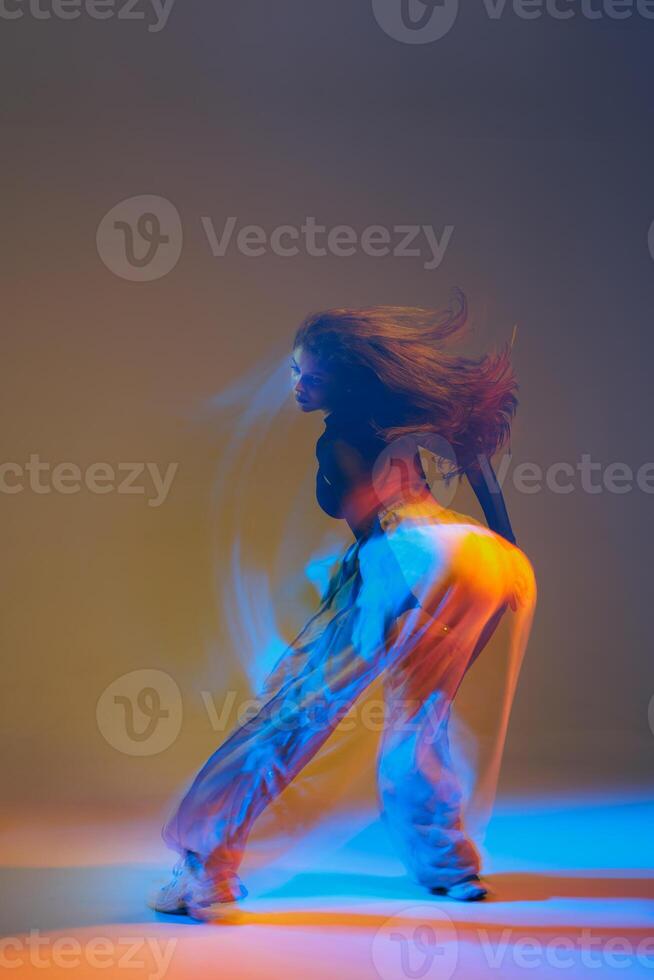 Energetic dancers in vibrant attire performing jazz-funk choreography in a modern studio, showcasing dynamic movements, expressive poses, and synchronized group formations. photo