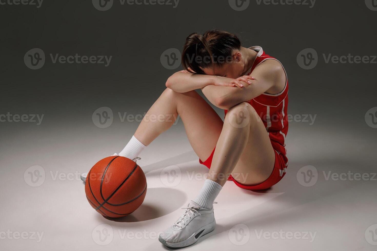 Basketball player sitting with head down photo